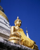 Seated golden Buddha statue robed in gold silk.Asian Prathet Thai Raja Anachakra Thai Religion Religious Siam Southeast Asia Siamese