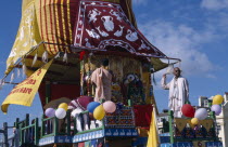 Hare Krishna taking part in a parade on Brighton seafront  with a colourful painted carriageEuropean Colorful Great Britain Northern Europe Religion UK United Kingdom