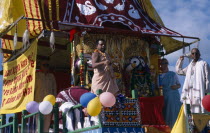 Hare Krishna taking part in a parade on Brighton seafront  with a colourful painted carriageEuropean Colorful Great Britain Northern Europe Religion UK United Kingdom