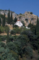 White church with red tilled dome on tree covered hillside European Ellada Greek Religious Southern Europe