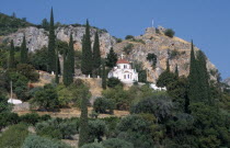 White church with red tilled dome on tree covered hillside European Ellada Greek Religious Southern Europe