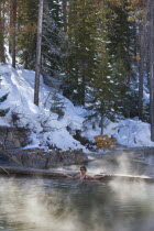 Woman in the outdoor hot pool of the spa resort.