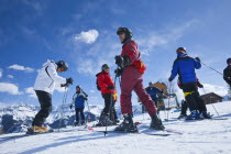 Group of skiers about to descend the mountain.