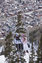 Skiers on ski lift chair.
