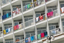 Hotel balconies with beach towels drying over balustrades.