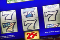 Detail of slot machine dials showing the lucky number seven and 25 cents to play.
