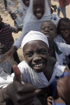 Tanji Village.  Happy  laughing children wanting to be photographed and trying to get the best position while having a break from lessons at the Ousman Bun Afan Islamic school.  Child in centre foregr...