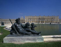 Bronze statue beside lake with palace behind and clear blue sky