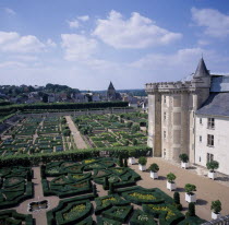 View looking down across gardens and corner of chateau  blue and cloudy sky.