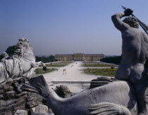 Schonbrunn Palace beyond approach path with horse and man statue in foreground