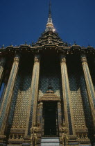 Wat Phra Kaeo. View looking up at golden facade columned entrance and statues