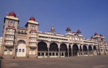 Angled view of exterior of Mysore Palace also known as Amba Vilas Palace with passing cyclist.