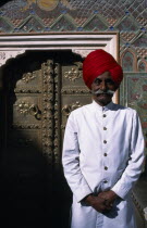 Palace guard wearing white with red turban