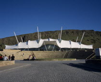 Holyrood Road.  Our Dynamic Earth Exhibition building exterior with Salisbury Craggs in the background.