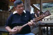 Man playing traditional stringed instrumentAsian Prathet Thai Raja Anachakra Thai Siam Southeast Asia Classic Classical Historical Male Men Guy Older Siamese History Male Man Guy
