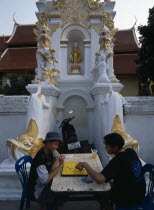 Wat Mahawan temple with two boys playing go on the pavement below temple wall carvingsAsian Kids Prathet Thai Raja Anachakra Thai Religion Siam Southeast Asia 2 Religious Siamese