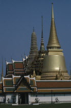 Aka Wat Phra Kaeo. Exterior view of golden spires and man on guard at the entranceMale Men Guy Prathet Thai Raja Anachakra Thai Religion Siam Southeast Asia Asian Male Man Guy Religious Siamese