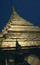 Wat Phra Kaew. Looking up to detail of statue standing under golden spirePrathet Thai Raja Anachakra Thai Religion Siam Southeast Asia Asian Religious Siamese