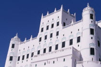 Sultans Palace with view of the top half of white plaster facade.