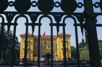 The Presidential Palace yellow painted exterior facade seen through metal gate railings.