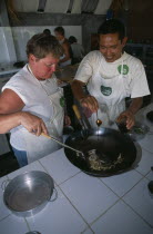 Cookery class at Time For Lime on Klong Dao beach. Instructor with tourist using a wokAsian Beaches Prathet Thai Raja Anachakra Thai Resort Sand Sandy Seaside Shore Siam Southeast Asia Tourism Holida...