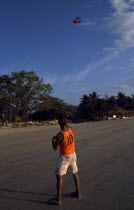 Klong Dao beach with a man on the sand flying a kiteAsian Beaches Prathet Thai Raja Anachakra Thai Resort Sandy Seaside Shore Siam Southeast Asia Tourism Male Men Guy Scenic Siamese Male Man Guy