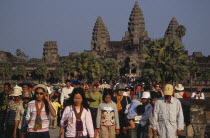Tourists on stone causeway leading to temple complex.  Many Cambodians visiting during Chinese New Year. Asian Kampuchea Religion Southeast Asia History Holidaymakers Kamphuchea Religious Tourism