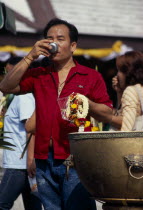 Wat Meuang the City pillar the most important animist shrine in Bangkok with male devotee drinking votive waterAsian Prathet Thai Raja Anachakra Thai Religion Siam Southeast Asia Religious Siamese