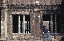 Child sitting in window of gallery in upper level. Asian Cambodian Children History Kampuchea Kids Religion Southeast Asia Kamphuchea Religious