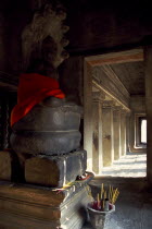 Interior of shrine on the upper level with Buddha figure seated below naga with multi headed hood and offerings of incense placed at the base. Asian Bonnet Cambodian History Kampuchea Religion Southe...