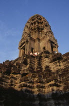Looking up at western tourists at base of lotus shaped tower in upper level.Asian Cambodian History Holidaymakers Kampuchea Religion Southeast Asia Tourism Kamphuchea Religious