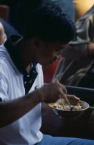 Damnoen Saduak Floating Market man sitting in a canoe eating noodles Asian Prathet Thai Raja Anachakra Thai Siam Southeast Asia Male Men Guy Siamese Male Man Guy