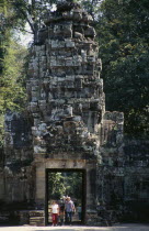 Preah Khan.  Western family framed beneath entrance tower of twelfth century temple complex built in the bayon style.Asian Cambodian Kampuchea Kids Religion Southeast Asia History Holidaymakers Kamph...