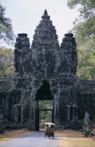 Tuk tuk carrying tourists approaching Victory Gate.Asian Cambodian Kampuchea Religion Southeast Asia History Holidaymakers Kamphuchea Religious Tourism