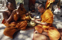 Buddhist monks eating steamed and boiled corn donated by elderly lady.Asian Cambodian Kampuchea Religion Southeast Asia Kamphuchea Old Senior Aged Religion Religious Buddhism Buddhists