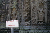 Preah Khan.  Sign prohibiting the defacement of stone in front of headless bas relief carvings of apsaras.  Raids by antique dealers were only made illegal in the 1990s.Asian Cambodian Kampuchea Reli...
