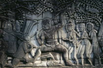 The Bayon.  Detail of bas relief carving on south wall depicting scenes of war.  Khmer soldiers spearing Cham soldiers wearing head dress.Asian Cambodian Kampuchea Southeast Asia History Kamphuchea