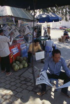 Men reading newspapers at a drinks stallAsian Cambodian Kampuchea Southeast Asia Kamphuchea Male Man Guy Male Men Guy