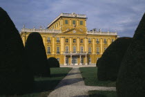 Esterhazy Palace yellow painted exterior seen from formal gardens with mature hedging
