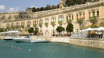 The waterfront redevelopment of old Baroque Pinto wharehouses below the bastion walls of Floriana beside the cruise ship terminal with boats moored alongside