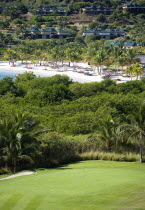 Raffles Resort Trump International Golf Course designed by Jim Fazio. The 8th green with the resort and Jambu beach beyond lined with coconut palm trees  palapas and sunbeds