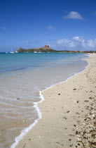 Pigeon Island National Historic Park seen from a nearby beach on a causeway to the island with yachts at anchor in Rodney Bay