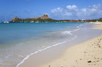 Pigeon Island National Historic Park seen from a nearby beach on a causeway to the island with yachts at anchor in Rodney Bay