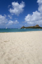 Pigeon Island National Historic Park seen from a nearby beach on a causeway to the island with yachts at anchor in Rodney Bay
