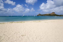 Pigeon Island National Historic Park seen from a nearby beach on a causeway to the island with yachts at anchor in Rodney Bay