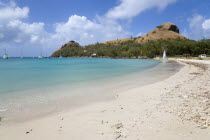 Pigeon Island National Historic Park seen from a nearby beach on a causeway to the island with yachts at anchor in Rodney Bay