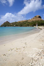 Pigeon Island National Historic Park seen from a nearby beach on a causeway to the island with yachts at anchor in Rodney Bay