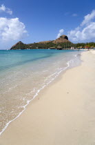 The beach at Sandals Grande St Lucian Spa and Beach Resort hotel with Pigeon Island National Historic Park beyond