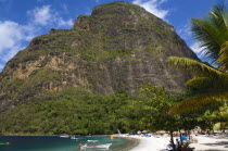Val des Pitons The white sand beach at the Jalousie Plantation Resort Hotel with the volcanic plug of Petit Piton beyond and tourists on sunbeds beneath palapa sun shades