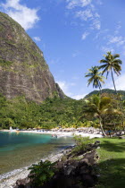 Val des Pitons The white sand beach at the Jalousie Plantation Resort Hotel with the volcanic plug of Petit Piton beyond and tourists on sunbeds beneath palapa sun shades